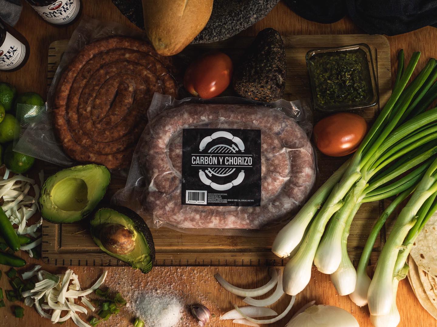 Chorizo argentino en tabla de cortar, rodeado de verduras